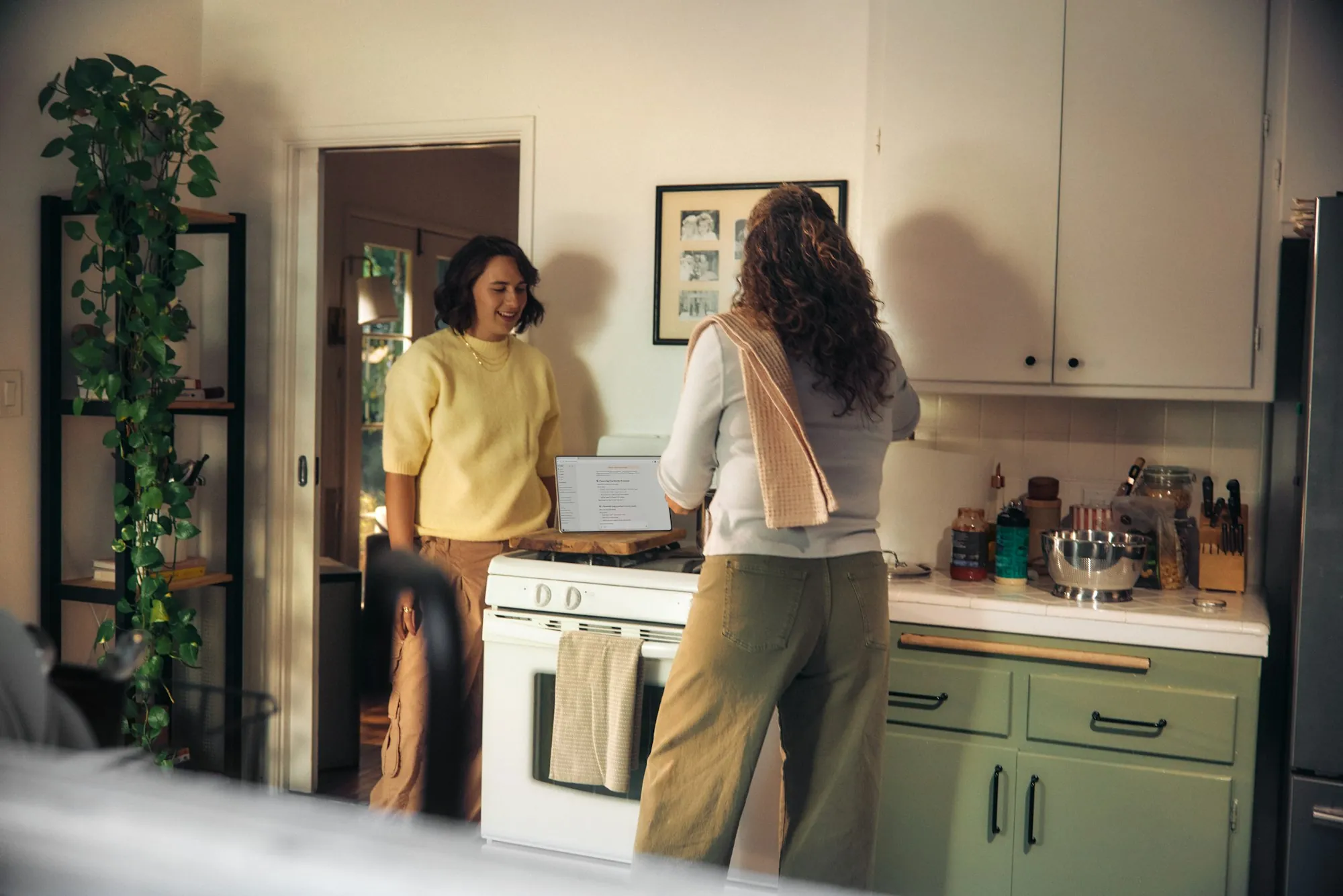 Two women talking together while cooking in a kitchen